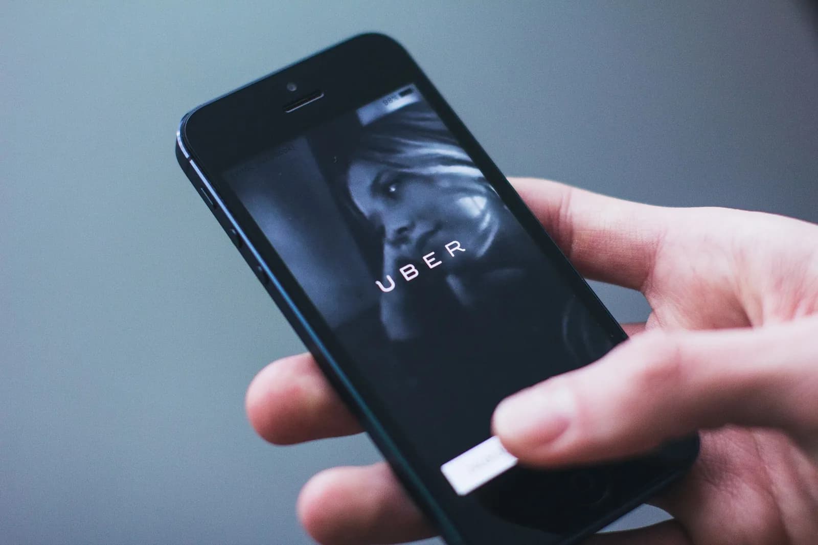 Main tenant un smartphone avec une application de VTC ouverte