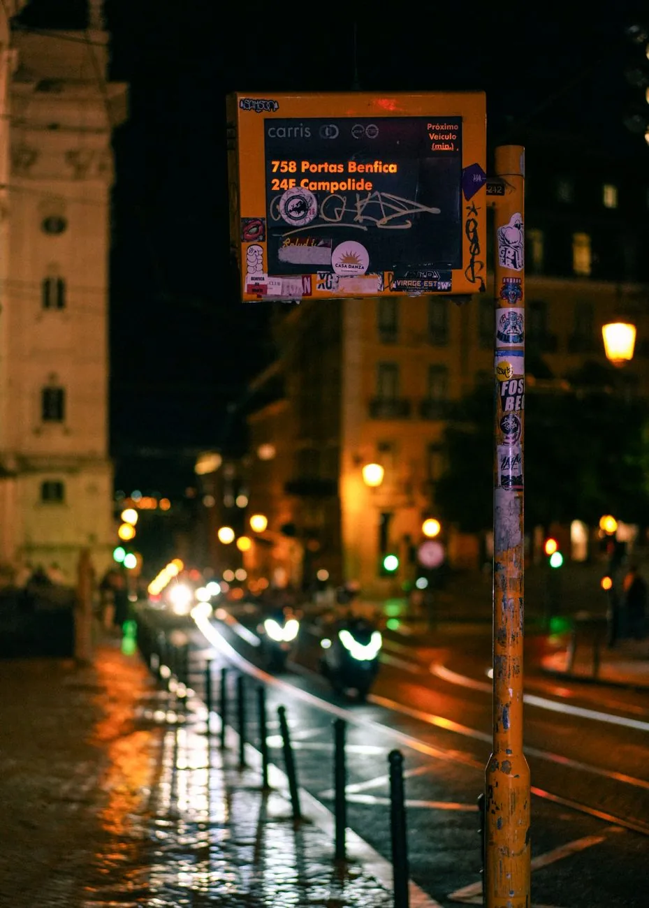 Panneau d'arrêt de bus éclairé dans une rue de Lisbonne la nuit