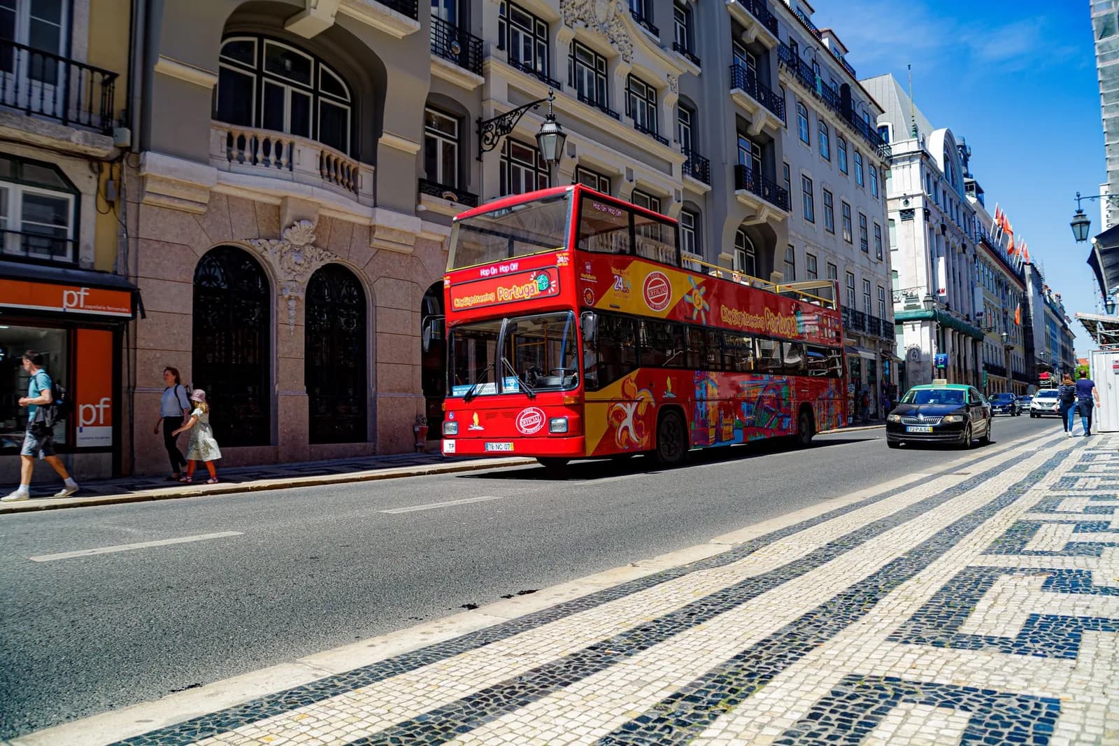 Bus touristique rouge à impériale dans une rue de Lisbonne