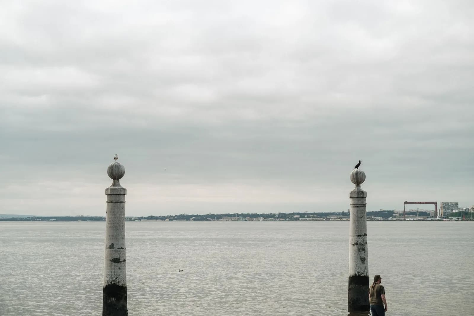Les deux colonnes du Cais das Colunas devant le Tage, par un matin gris et calme