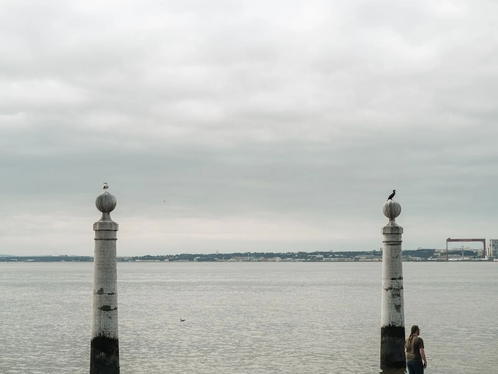 Les deux colonnes du Cais das Colunas qui plongent dans le Tage à Lisbonne, sous un ciel nuageux