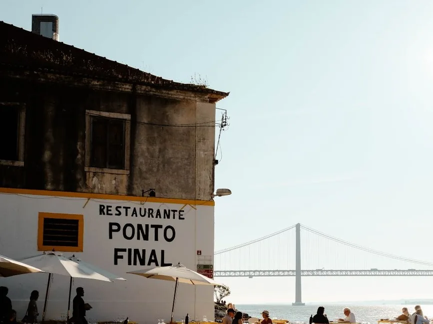 Le restaurant Ponto Final dans un ancien bâtiment délabré du Cais do Ginjal, avec le pont du 25-Avril au loin