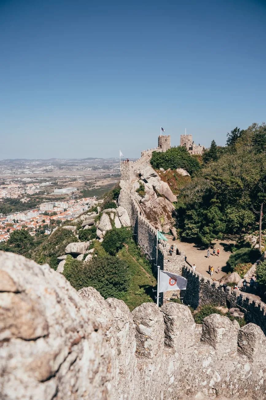 Remparts de pierre du château des Maures sur la crête de la serra de Sintra, avec la ville en contrebas