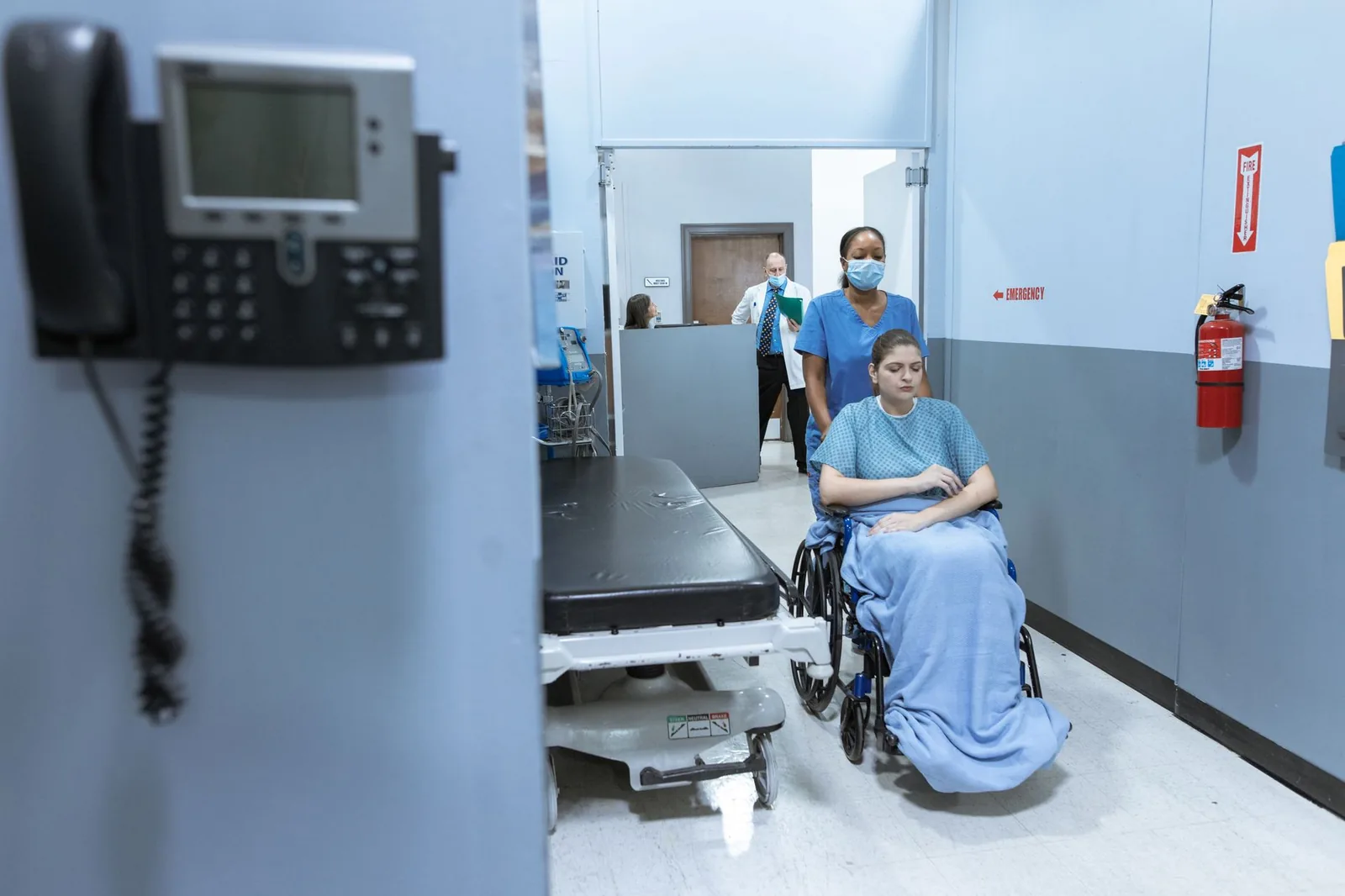 Couloir d'hôpital, une patiente en fauteuil roulant