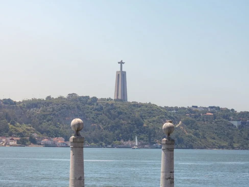 Le Cristo Rei sur la colline d'Almada, vu de Lisbonne par-dessus le Tage, entre les deux colonnes du Cais das Colunas
