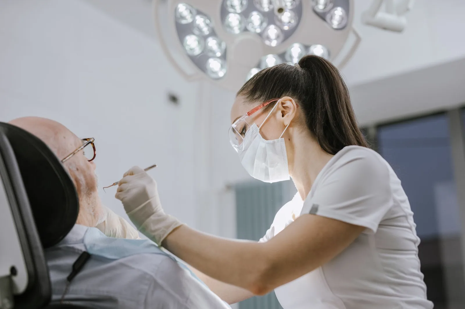 Une dentiste soigne un patient âgé