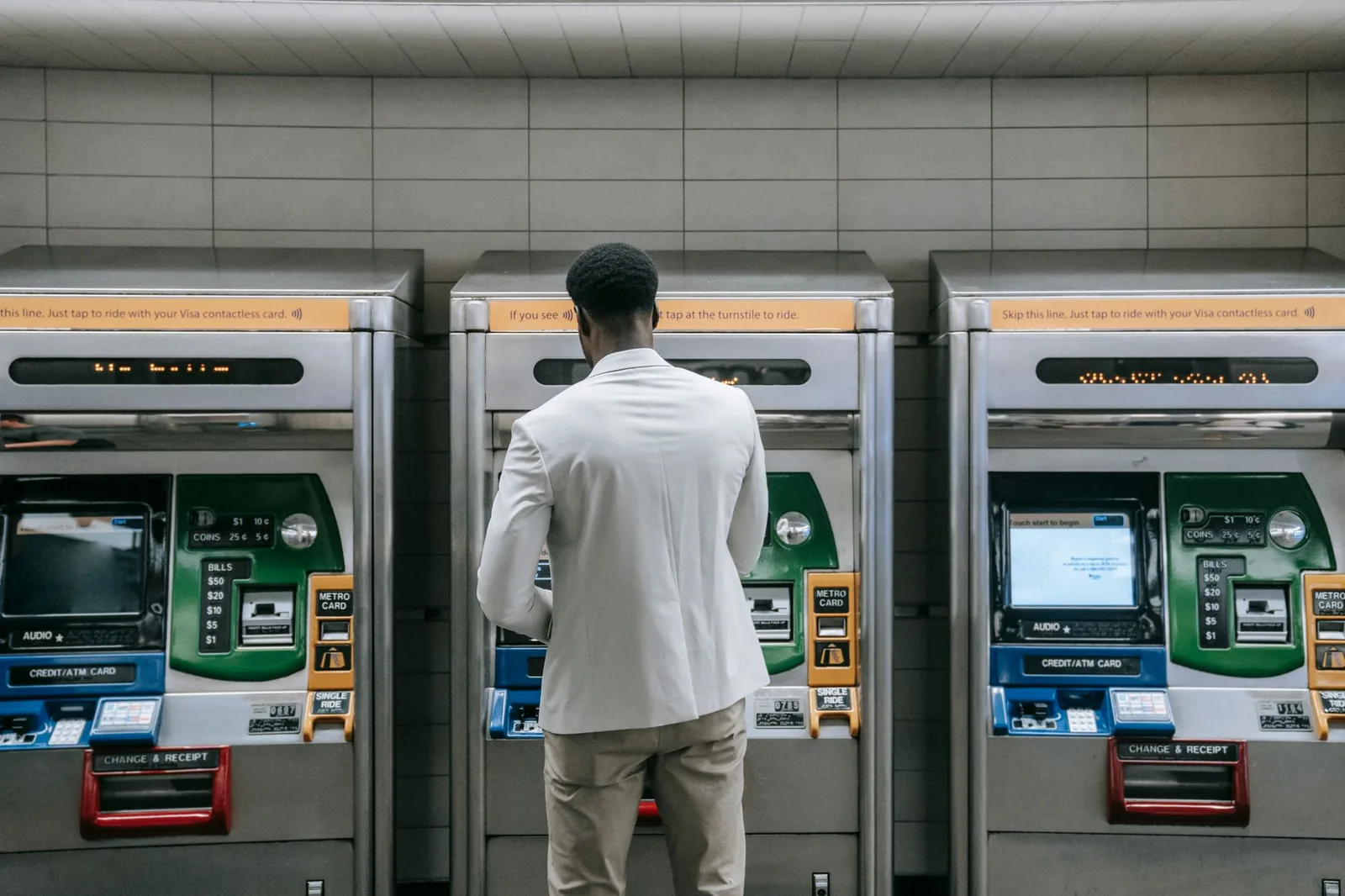 Voyageur devant des distributeurs automatiques de titres dans une station de métro