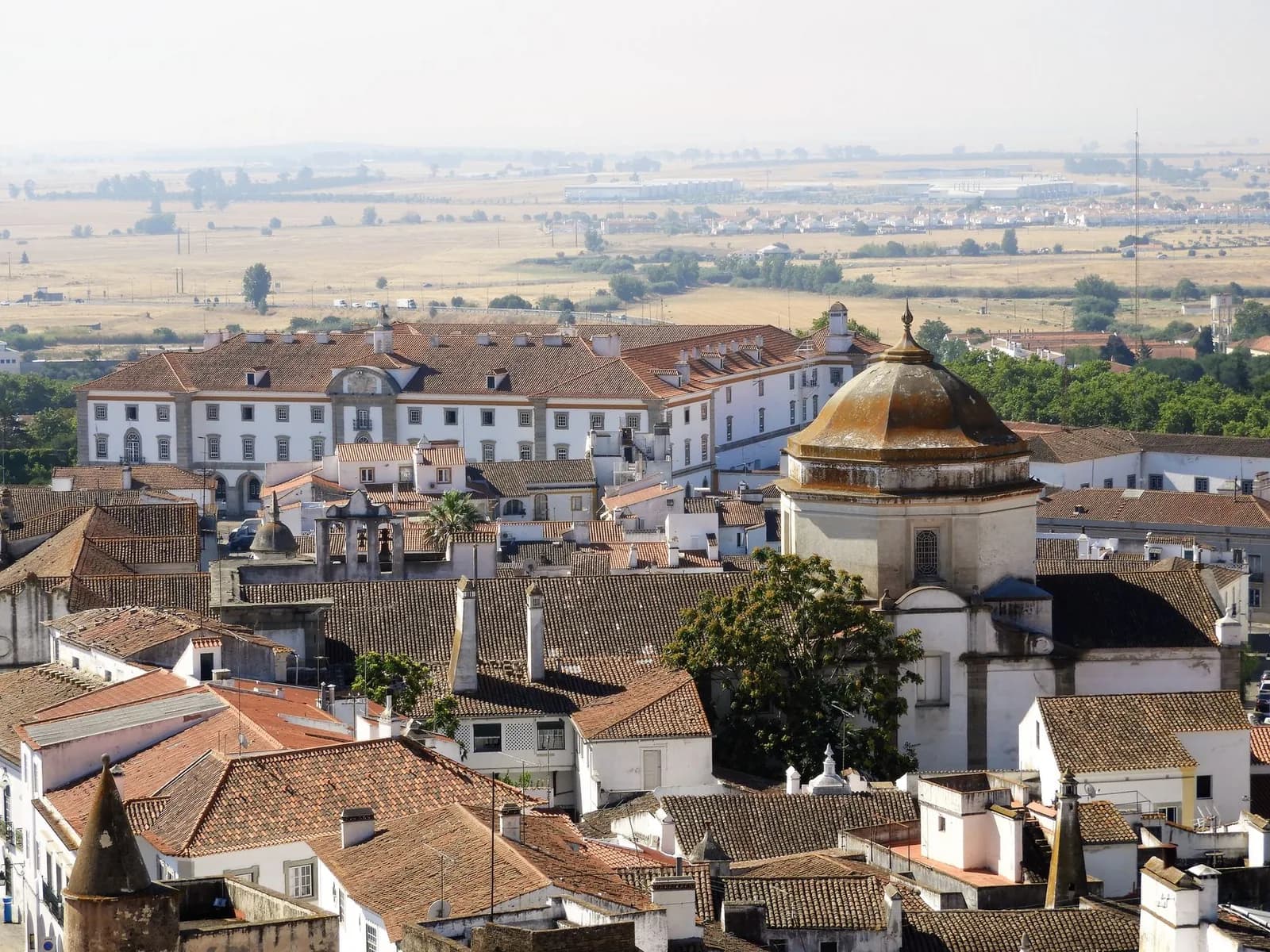 Toits de tuiles et dôme du centre historique d'Évora, plaine de l'Alentejo au loin