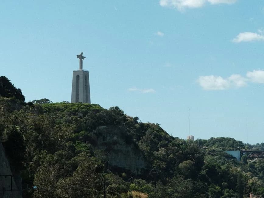 La falaise boisée d'Almada au-dessus du Tage, surmontée du Cristo Rei