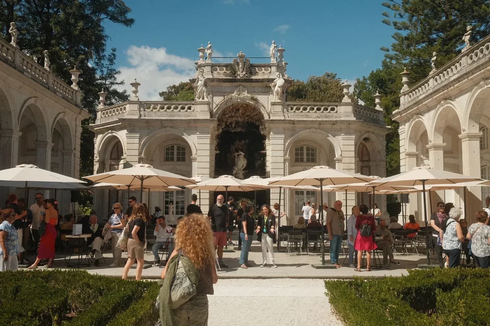Le jardin baroque d'un palais de Lisbonne, animé, avec parasols et promeneurs
