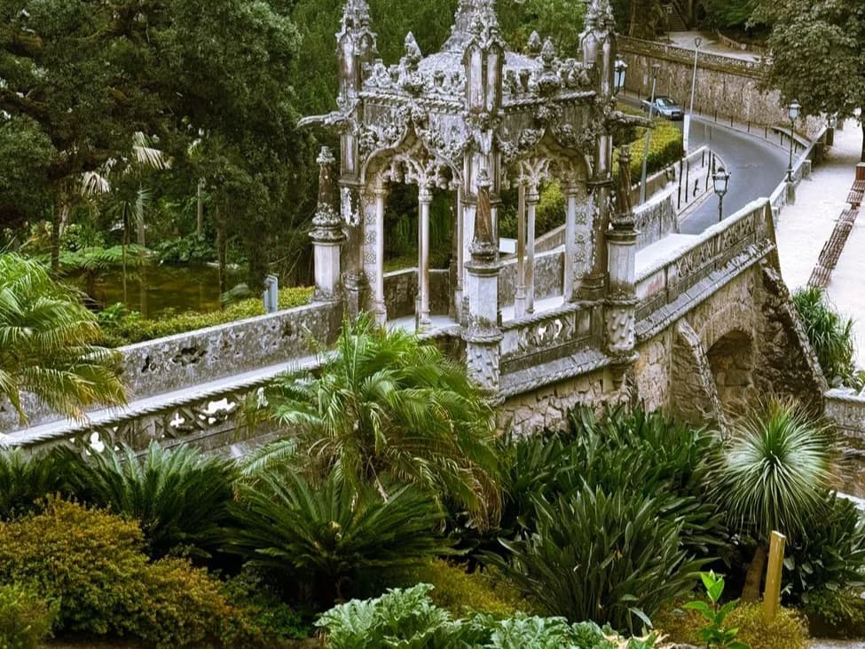 Pavillon de pierre ouvragé au milieu des jardins boisés de la Quinta da Regaleira, à Sintra