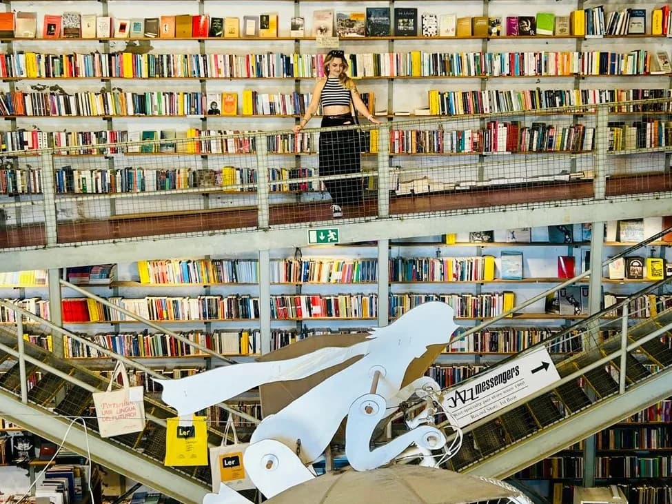 Librairie Ler Devagar à la LX Factory, Lisbonne : rayonnages jusqu'au plafond, escaliers métalliques et vélo blanc suspendu