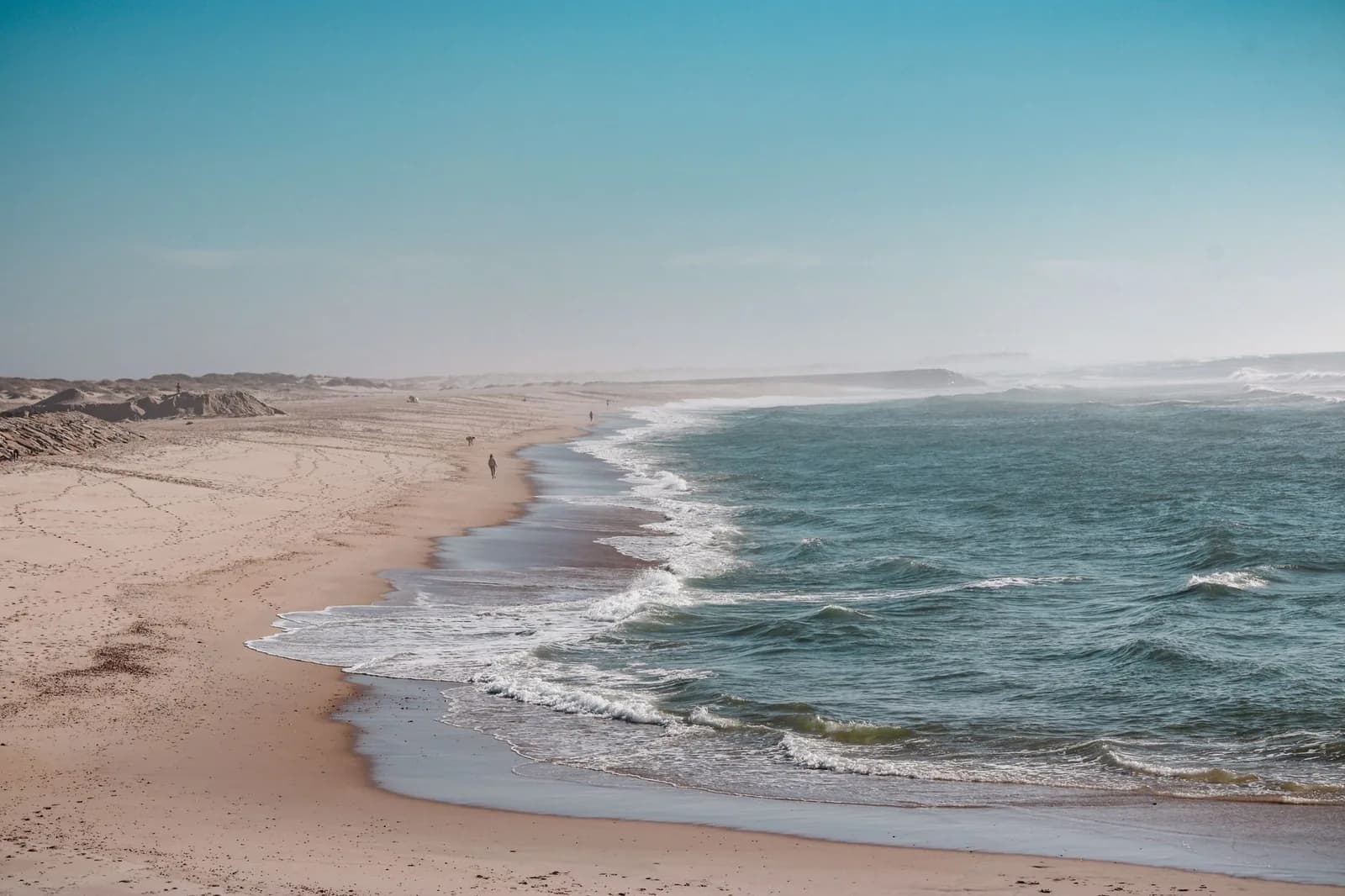 Longue plage de sable déserte face à l'océan