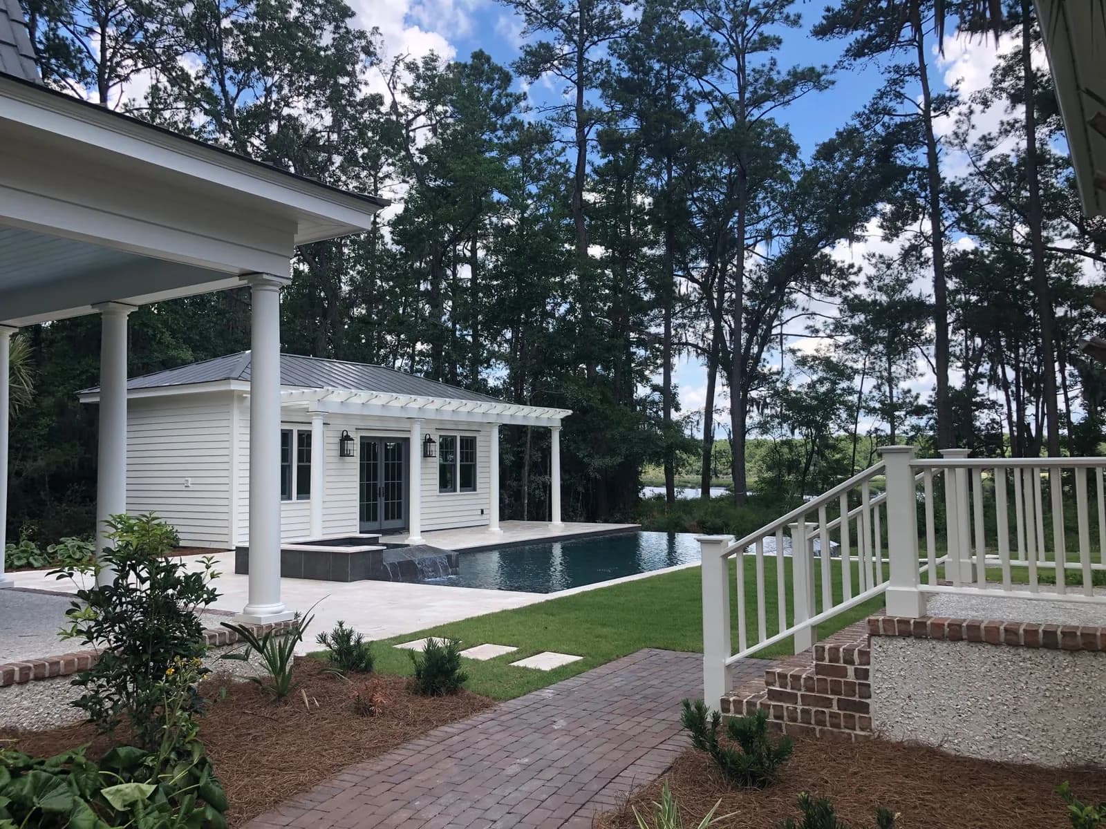 Maison blanche et piscine au milieu des pins