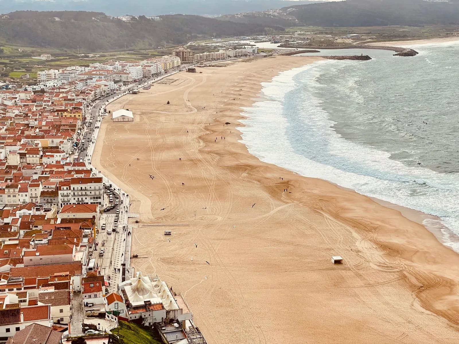 Vue plongeante sur la longue plage de sable et les toits de Nazaré