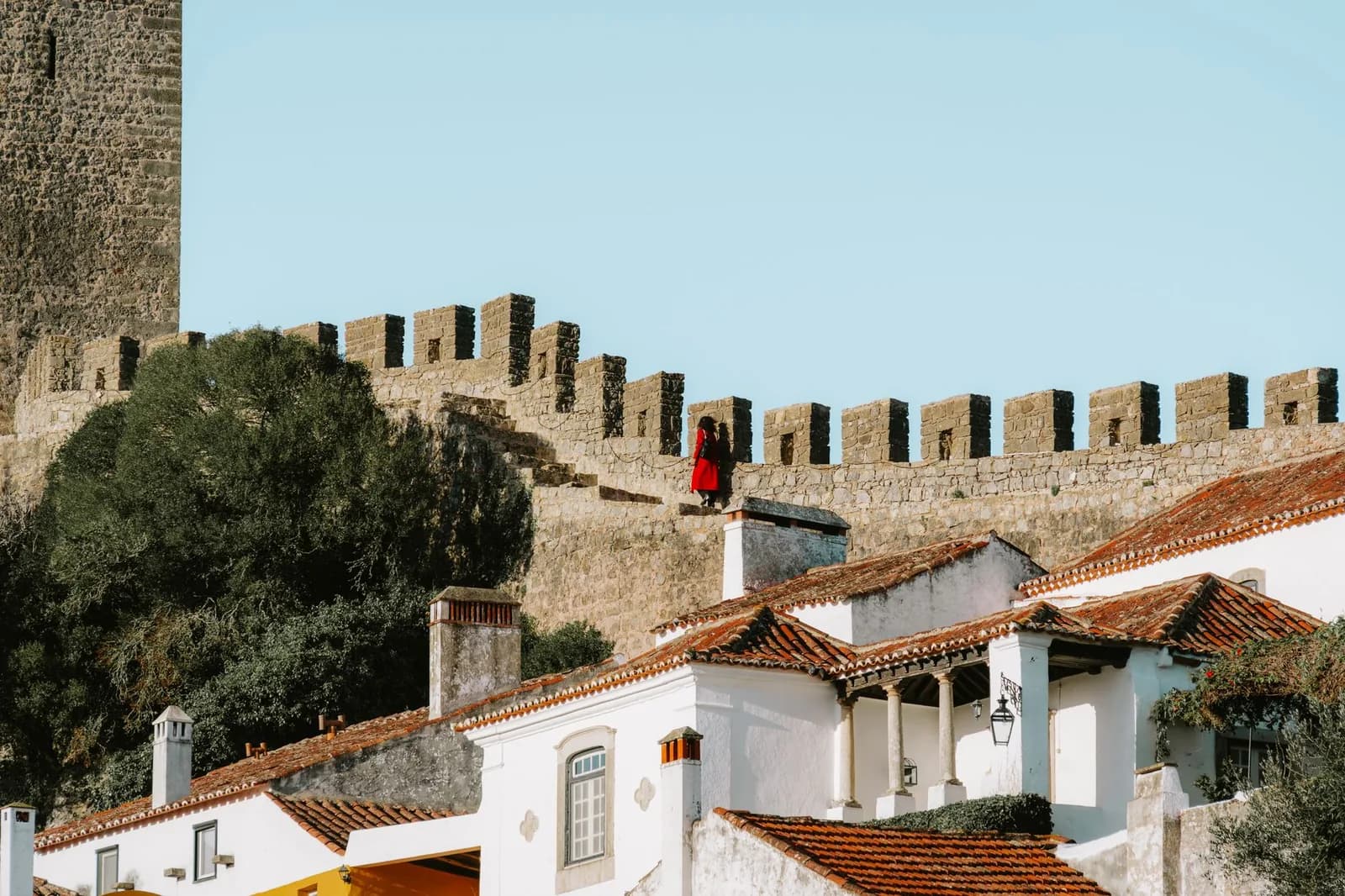 Remparts crénelés et tour du château d'Óbidos au-dessus des maisons blanches