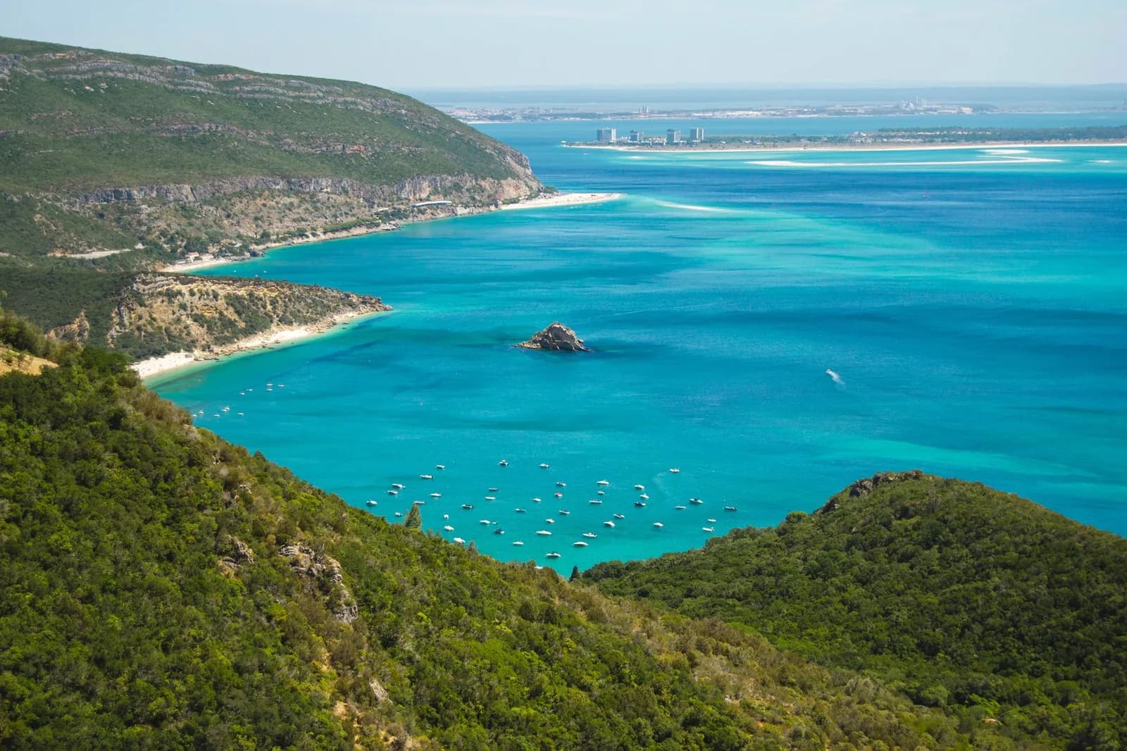 Panorama sur la baie turquoise et les versants boisés de la Serra da Arrábida