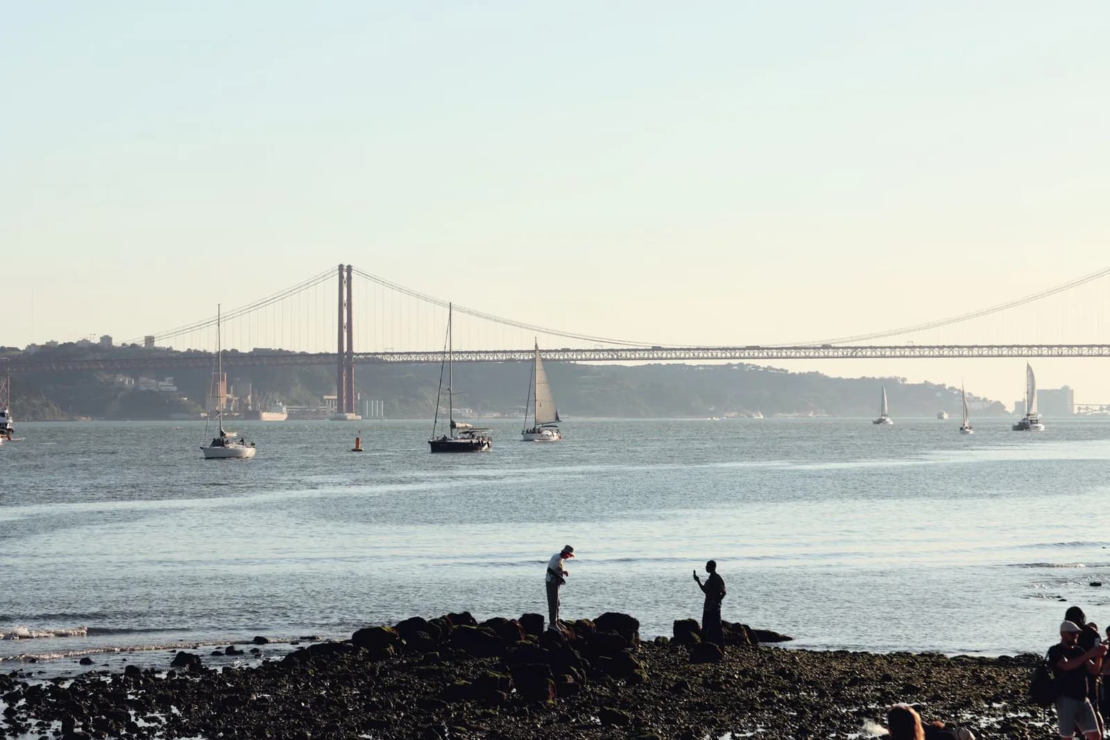 Le pont du 25-Avril et des voiliers sur le Tage, vus depuis la rive de Lisbonne