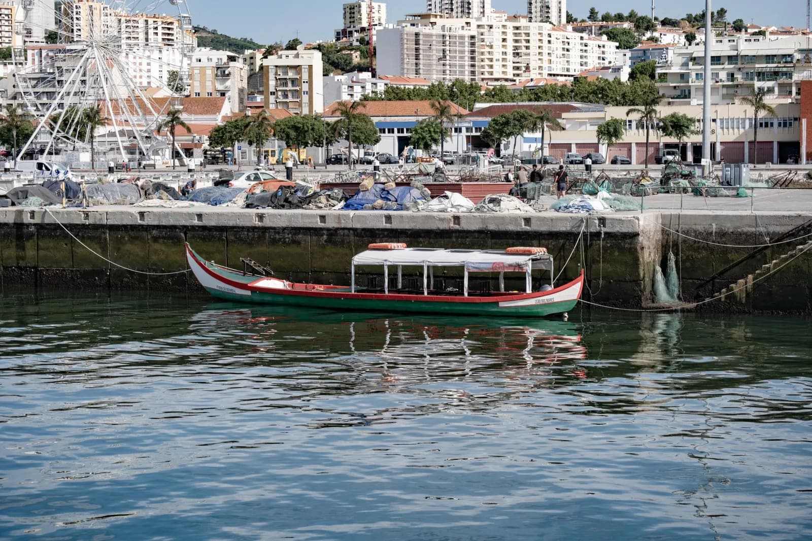 Bateau traditionnel amarré dans un port, immeubles de la ville en arrière-plan