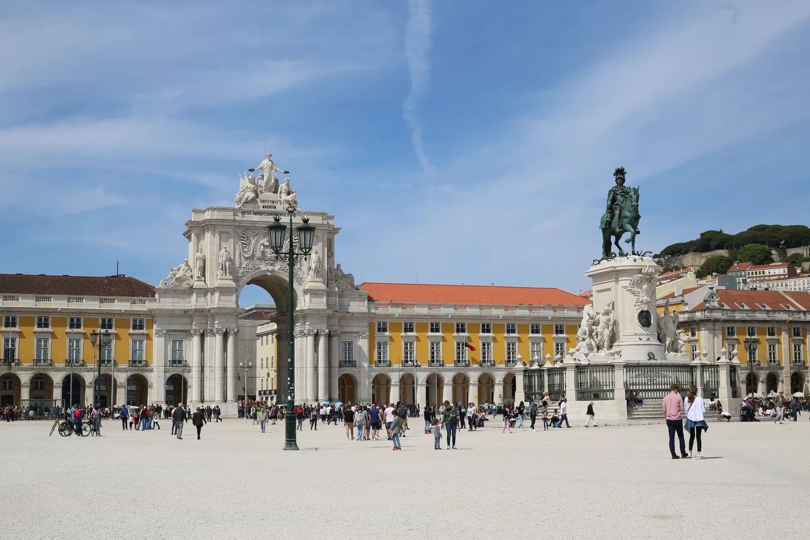 La Praça do Comércio à Lisbonne, avec la statue équestre de José Ier, l'Arco da Rua Augusta et les arcades jaunes sous un ciel bleu