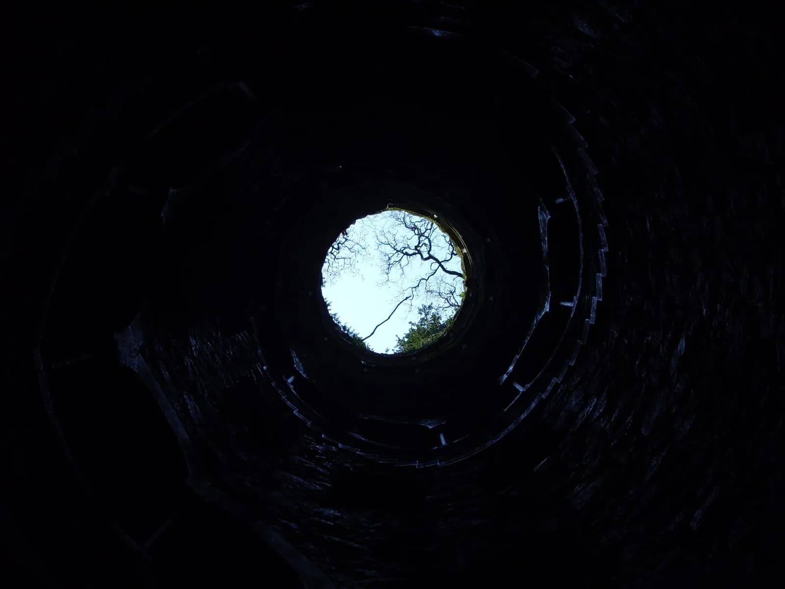 Cercle de lumière vu depuis le fond d'un puits obscur