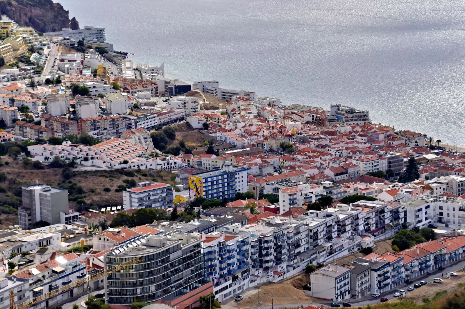 Vue aérienne de Sesimbra : les maisons blanches aux toits orange descendent vers la mer, au Portugal