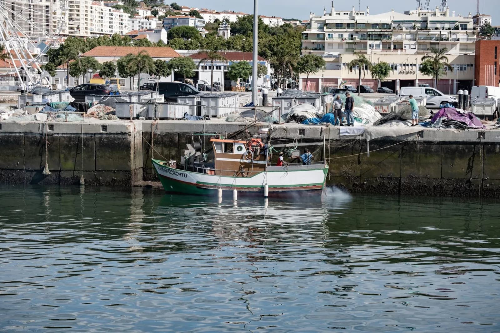 Bateau de pêche amarré dans le port de Setúbal, avec le front de mer en arrière-plan, au bord de l'estuaire du Sado