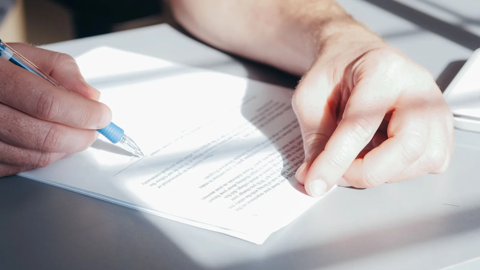 Main signant un contrat au stylo