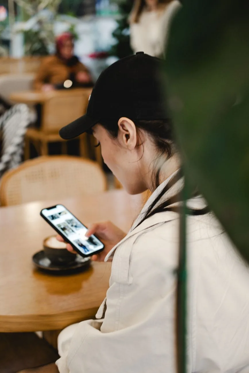 Voyageuse consultant son smartphone à la terrasse d'un café