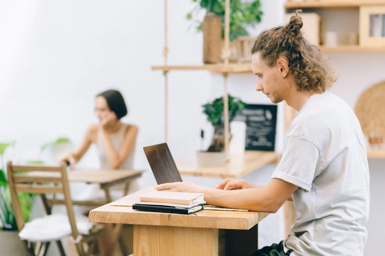 Homme travaillant sur son ordinateur portable dans un café lumineux