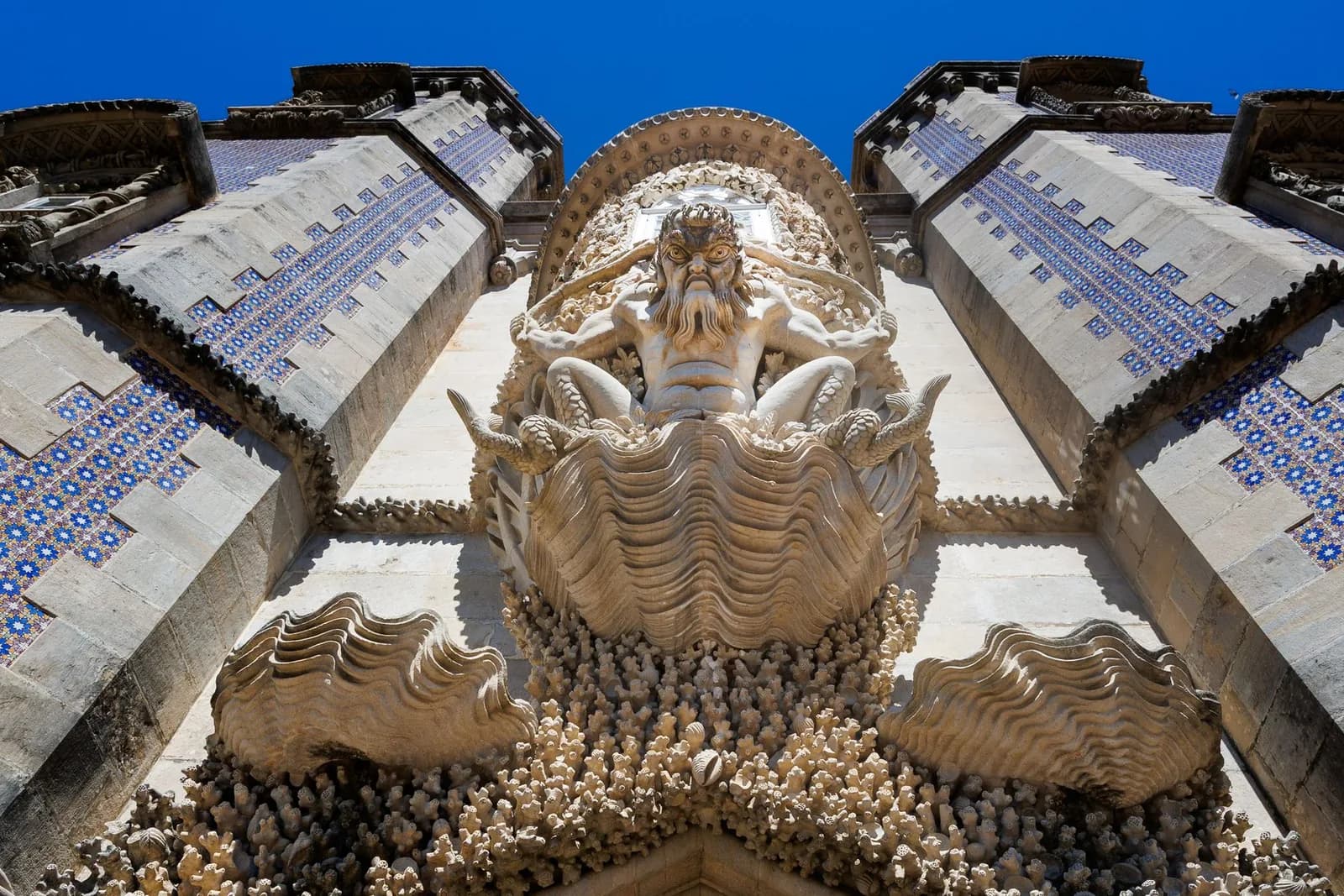 L'arche du Triton, créature mi-homme mi-poisson sculptée dans un décor de coquillages, entre deux murs d'azulejos bleus au palais de Pena