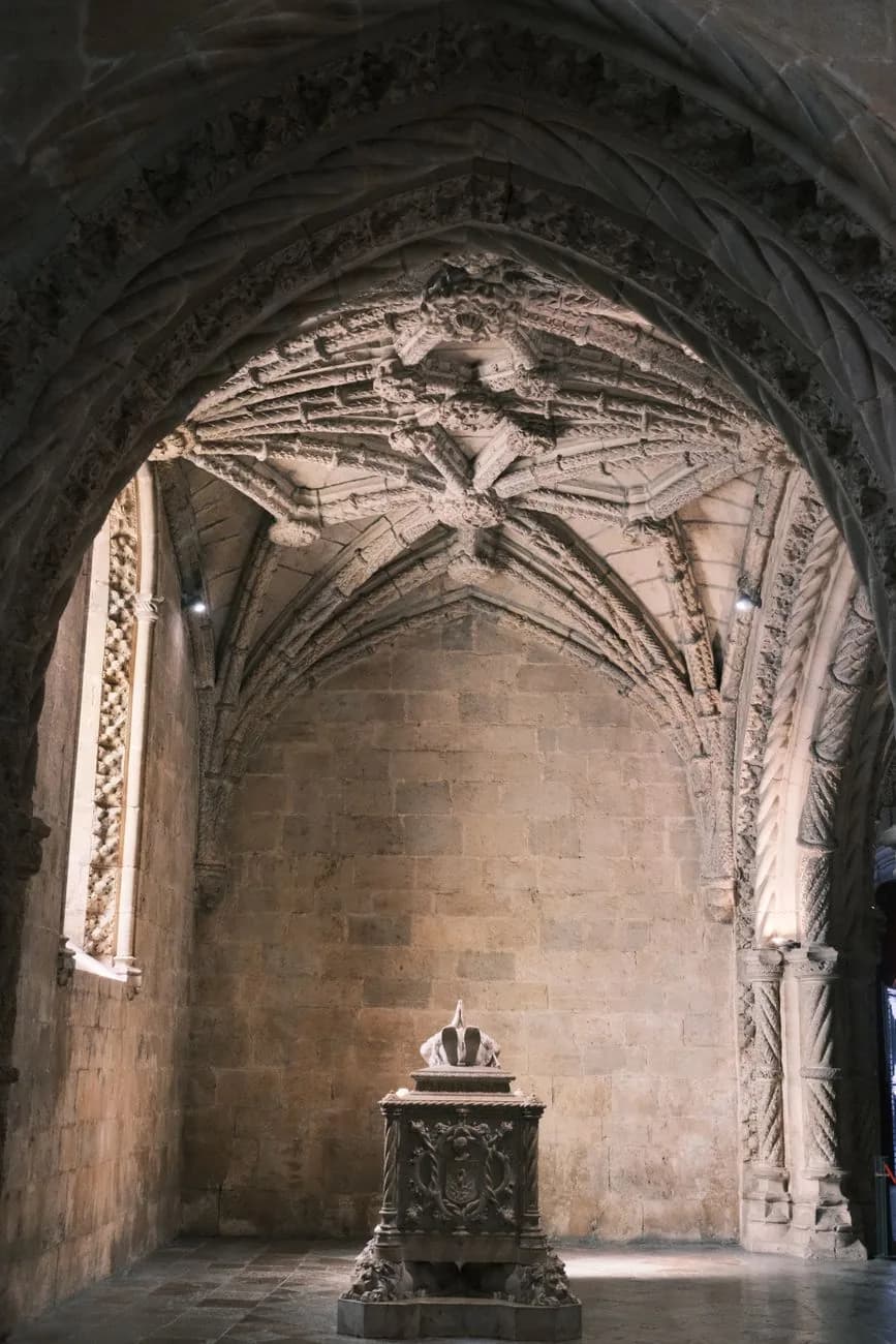 Tombeau de pierre sculpté sous une voûte nervurée