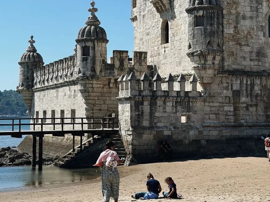 Le bastion de la tour de Belém à Lisbonne, avec ses guérites crénelées, sa passerelle en bois et la plage du Tage au pied des murs