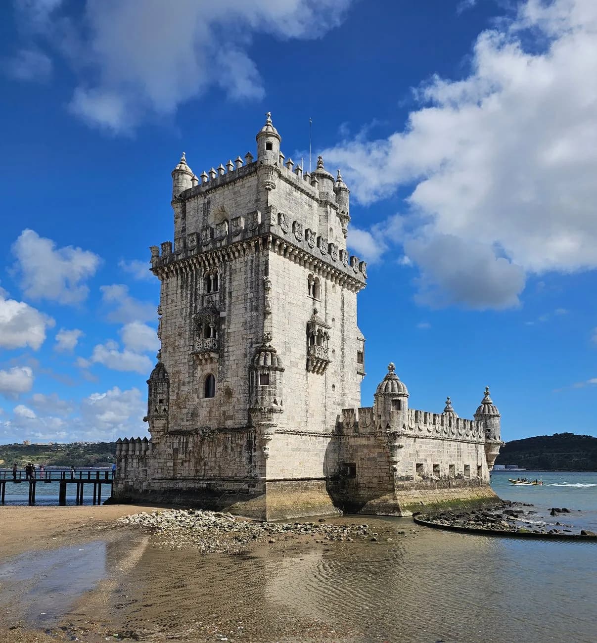 La tour de Belém et sa pierre claire sous un ciel nuageux, au bord du Tage