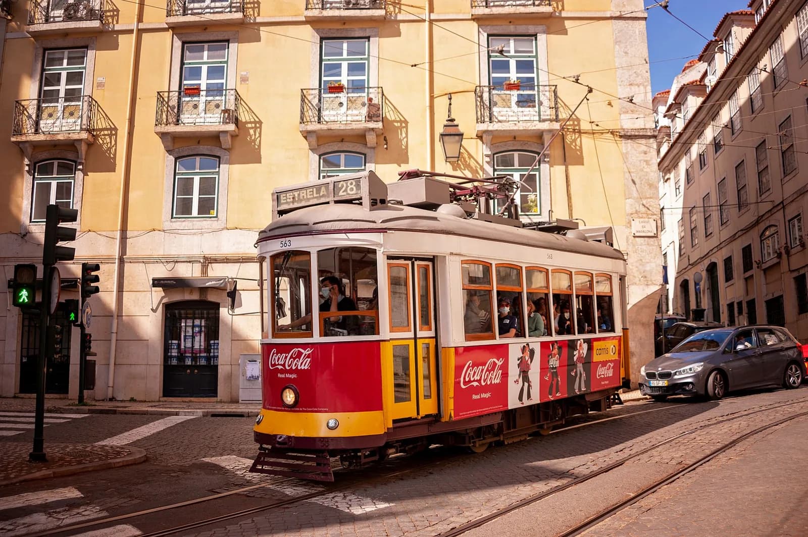 Tramway historique à un carrefour du centre de Lisbonne, entre façades ocre