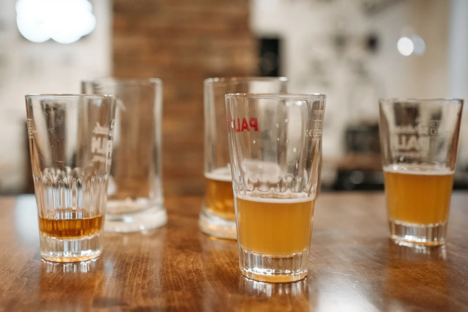 Verres de bière de dégustation alignés sur un comptoir en bois