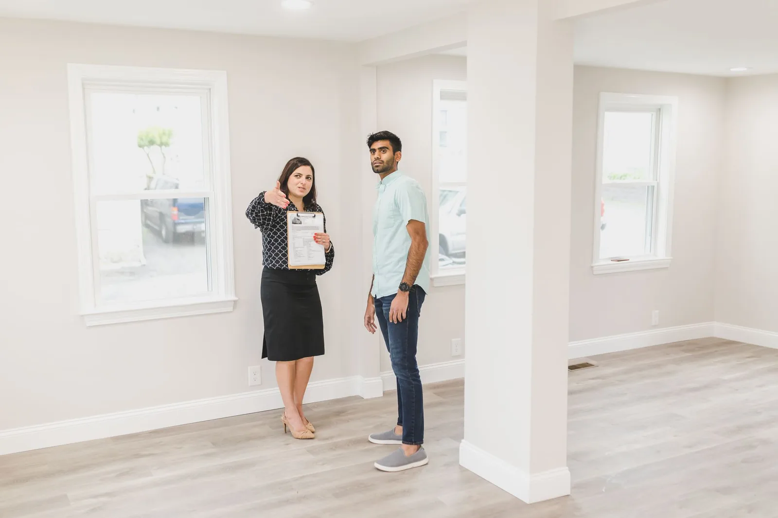 Agente immobilière faisant visiter un appartement vide à un acheteur